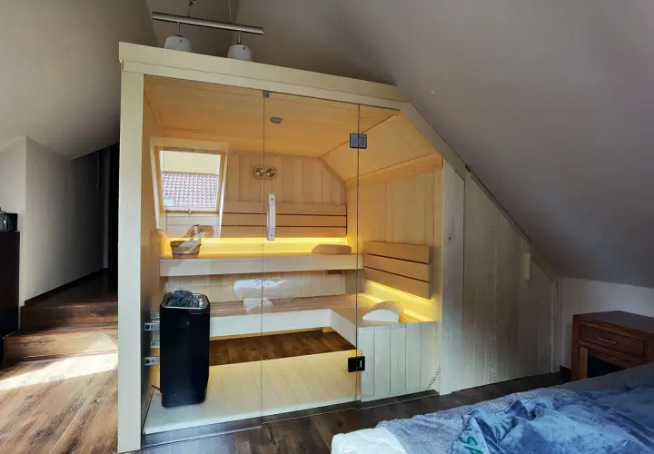 Nowoczesna sauna w domu, z przeszklonymi drzwiami i nastrojowym oświetleniem. Idealne miejsce na relaks.