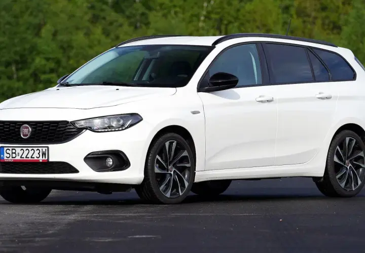 Biały Fiat Tipo kombi na tle zieleni. Wiele osób szuka takich aut, sprawdzając fiat tipo opinie.