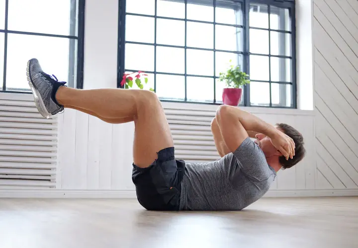 Hombre haciendo abdominales, parte de una rutina de ejercicios para bajar barriga.