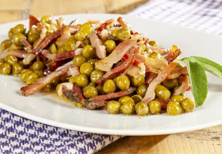 Un piatto invitante di piselli e pancetta croccante, guarnito con foglie di salvia fresca. Un classico sapore italiano.