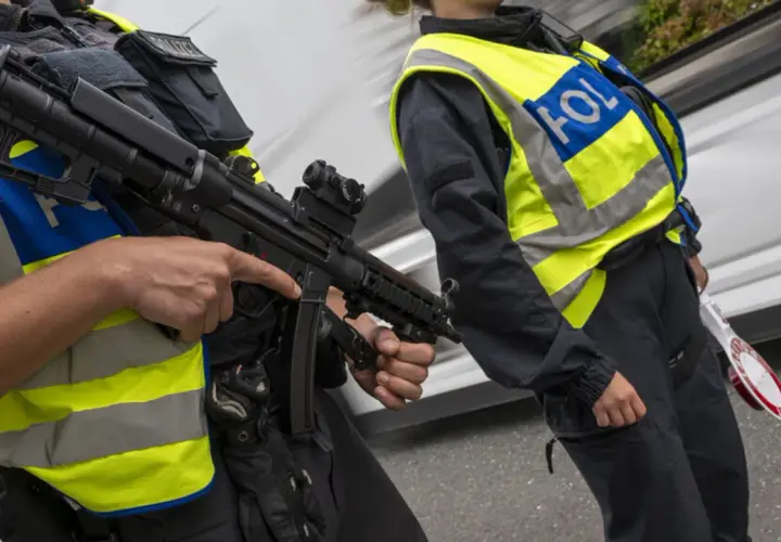 Zwei Polizisten mit Maschinenpistolen und Warnwesten führen Grenzkontrollen in Italien durch.
