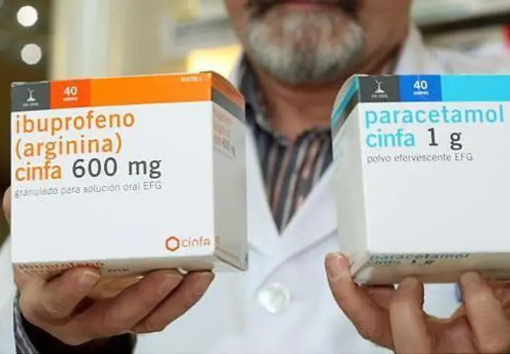 Manos sostienen cajas de medicamentos. Una caja muestra "ibuprofeno cinfa 600 mg" y la otra "paracetamol cinfa 1 g". Ambos son para la fiebre paracetamol o ibuprofeno.