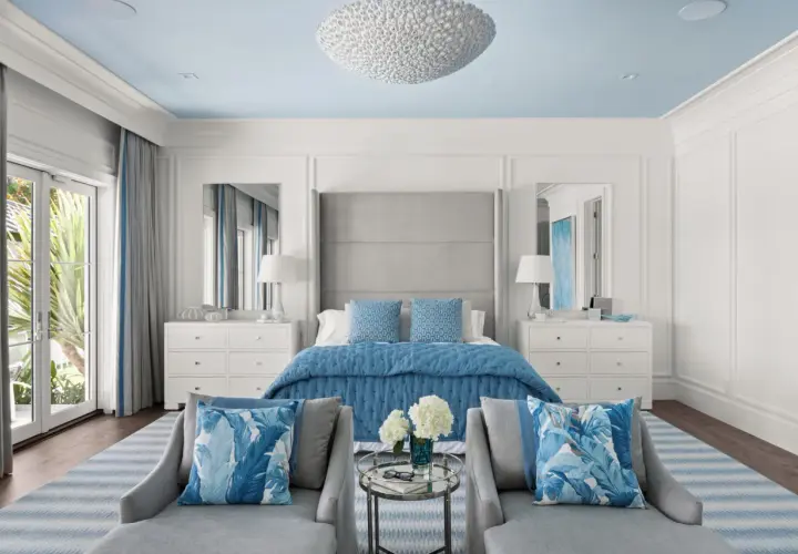 Serene master bedroom layout ideas with a blue and white palette, featuring a plush bed, mirrored nightstands, and comfortable seating.