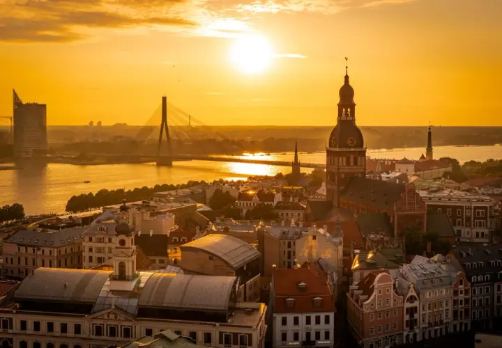 Zachód słońca nad Rygą. Widok na katedrę, most i nowoczesne budynki. Warto zobaczyć w Rydze to miasto pełne kontrastów.