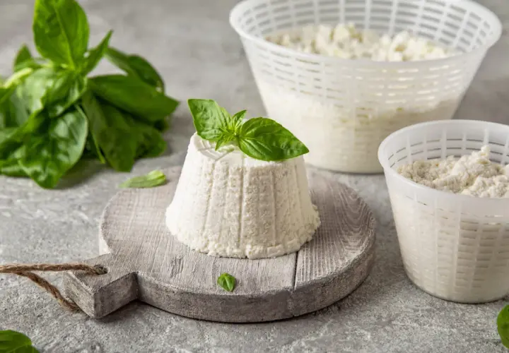 Świeża ricotta z bazylią, idealna do sałatek i deserów. Ten delikatny ser ma subtelny, kremowy smak.
