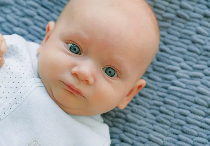 Occhi di un neonato di un blu intenso, quasi neon, che catturano lo sguardo.
