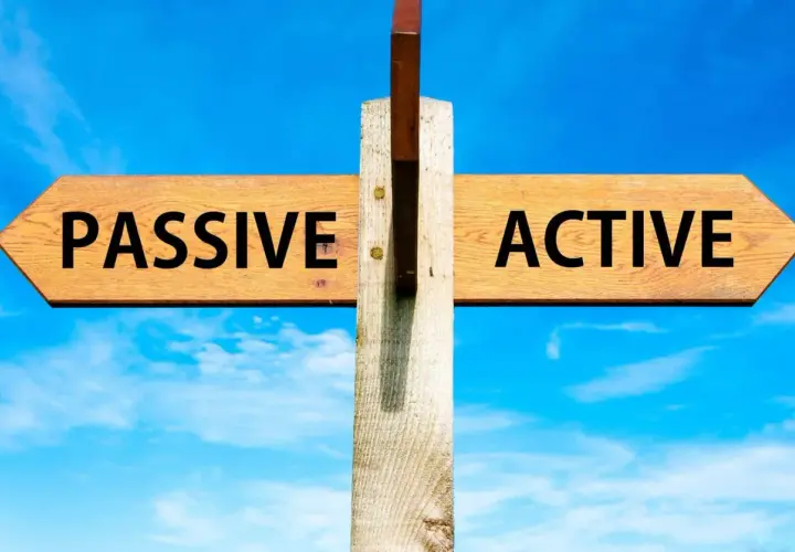 Cartello stradale con frecce "PASSIVE" e "ACTIVE" sotto un cielo azzurro. La scelta tra essere passivi o attivi è presentata.
