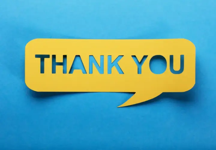 Un fumetto giallo ritagliato con la scritta "THANK YOU" su sfondo blu. Un modo per dire "prego" o "di niente" quando qualcuno ti ringrazia.