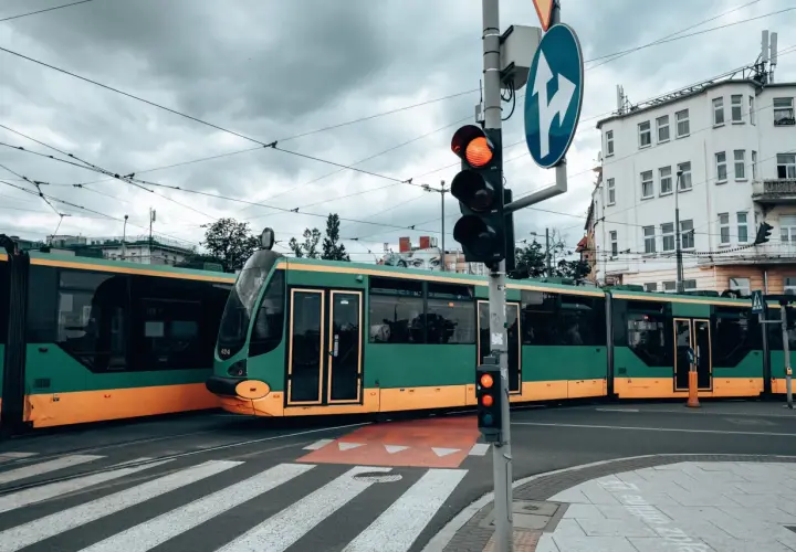 Zielony tramwaj w Poznaniu czeka na zielone światło. Gdzie kupić bilet na tramwaj poznań?