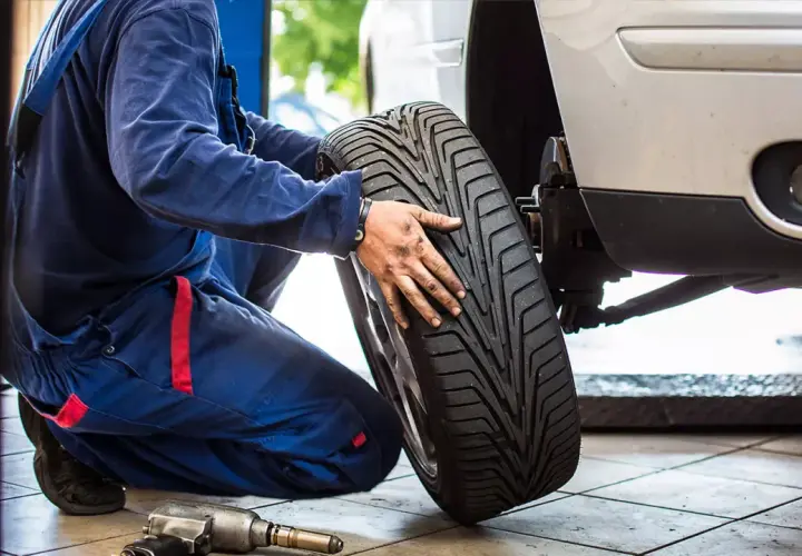 Mechanik wymienia oponę w Toyocie Yaris. Sprawdza rozmiar opon przed montażem.