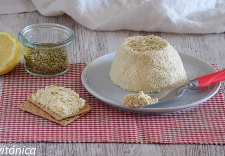 Deliciosa ricotta vegana con hierbas, servida en un plato con galletas y limón.