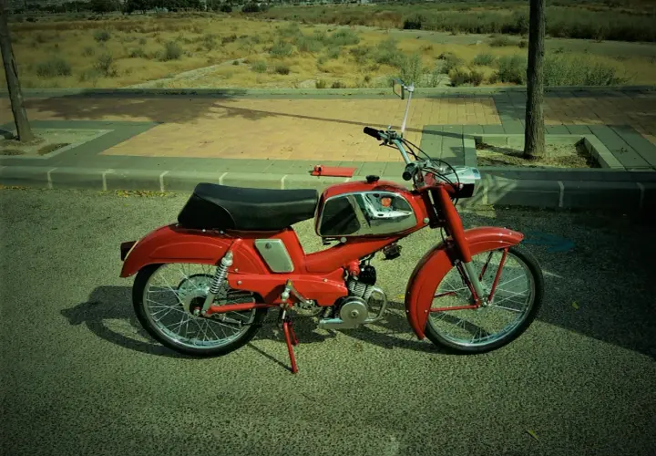 Ciclomotor rojo antiguo, listo para pasar la itv. Un clásico que evoca tiempos pasados.