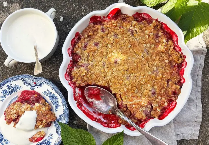 En härlig hallonpaj med krispig topping, serverad med vaniljsås. Perfekt för ett somrigt fika.
