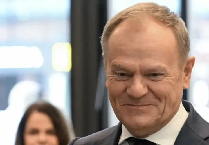 Uśmiechnięty Donald Tusk w garniturze. Ciekawe, ile Tusk ma emerytury na rękę, gdyby ją pobierał.