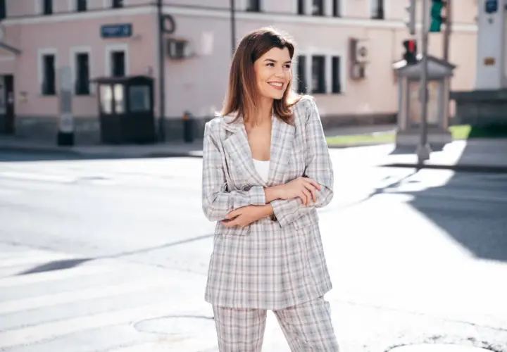 Kobieta w kraciastym garniturze, idealna odpowiedź na pytanie: jaka marynarka do spodni w kratę. Stylowy komplet na ulicy.