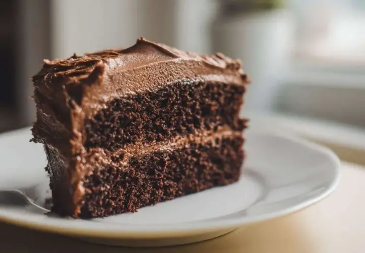Une part généreuse de cake au chocolat, avec un glaçage onctueux et une texture moelleuse. Un délice pour les amateurs de chocolat.