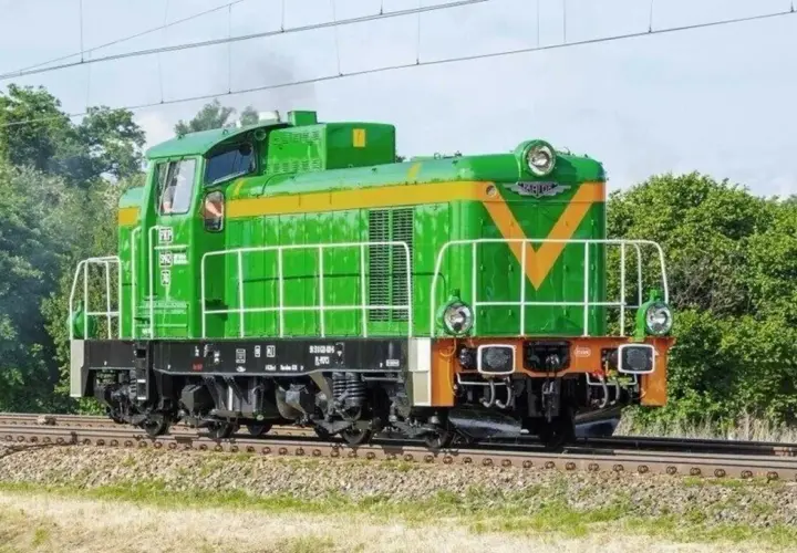 Zielona lokomotywa **Fablok 6D** z żółtym pasem i literami "PKP" na tle zieleni.