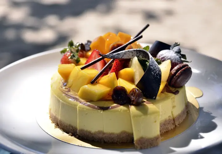Jak udekorować tort dla chłopca? Kolorowy tort z mango, truskawkami i czekoladą, idealny na przyjęcie.
