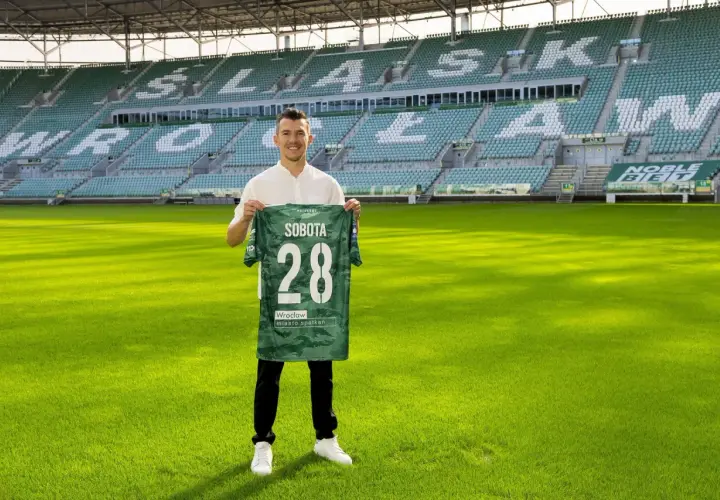Piłkarz z koszulką "Sobota 28" na tle stadionu. To jeden z nowych śląsk wrocław transfery.