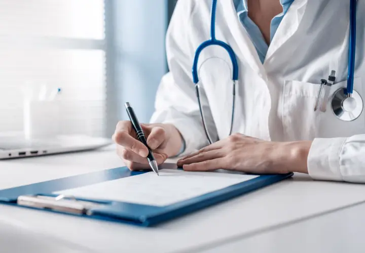 Medico scrive su cartella clinica. Se l'oculista sbaglia, chi paga per l'errore medico?