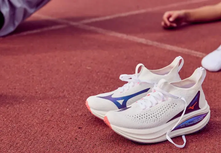 Białe buty do biegania Mizuno Neo Vista 2 z niebieskimi akcentami na bieżni.