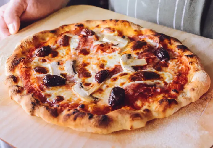 Idealna pizza na kamieniu: chrupiące ciasto, ciągnący ser, oliwki i pieczarki. Sekret jak piec pizze na kamieniu tkwi w wysokiej temperaturze.