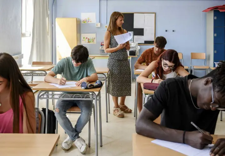 Des élèves concentrés passent un examen en classe, peut-être pour une bourse college.