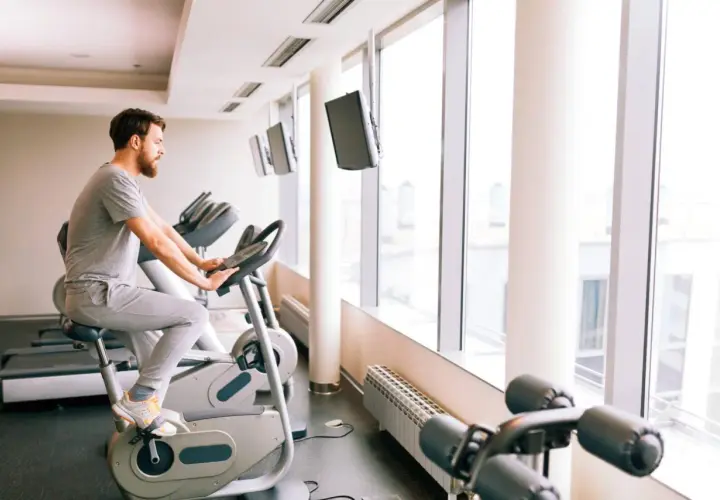 Mężczyzna ćwiczy na rowerze stacjonarnym, który może być dobrym wyborem, jeśli zastanawiasz się, jaki rower stacjonarny do rehabilitacji kolana wybrać.