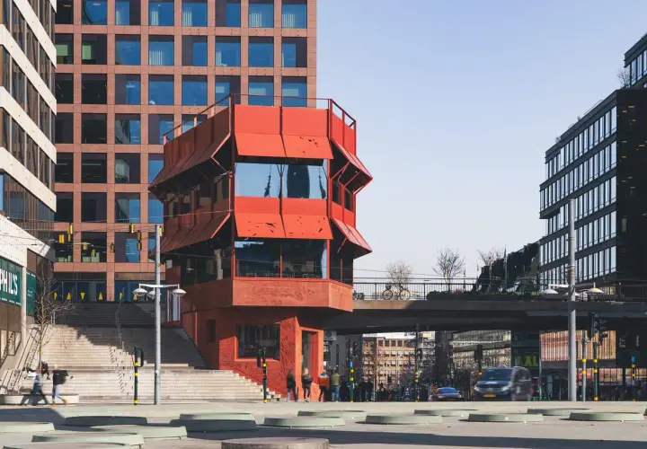 Rött, unikt hus vid Sergels torg, med trappor och moderna byggnader runtom. En plats för bio och möten.