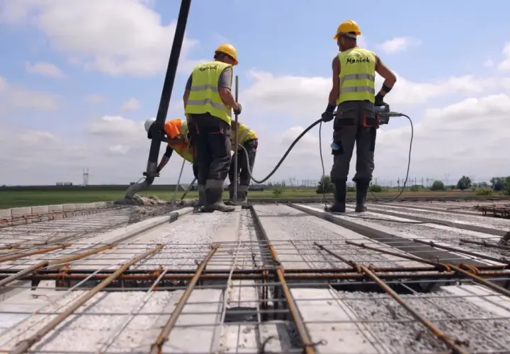 Budowa stropu: pracownicy wylewają beton, używając pompy. Jaki beton na strop? Ten, który zapewni trwałość konstrukcji.