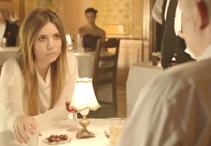 Lykke Li w białej bluzce, zamyślona przy stoliku. Czyżby "sadness is a blessing"?