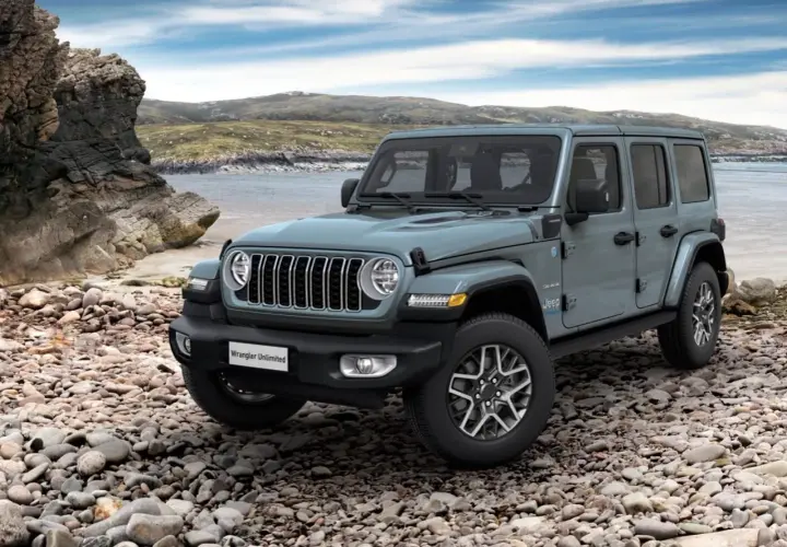 Szary Jeep Wrangler Unlimited na kamienistej plaży. Idealny na przygodę, rozważ jeep leasing.
