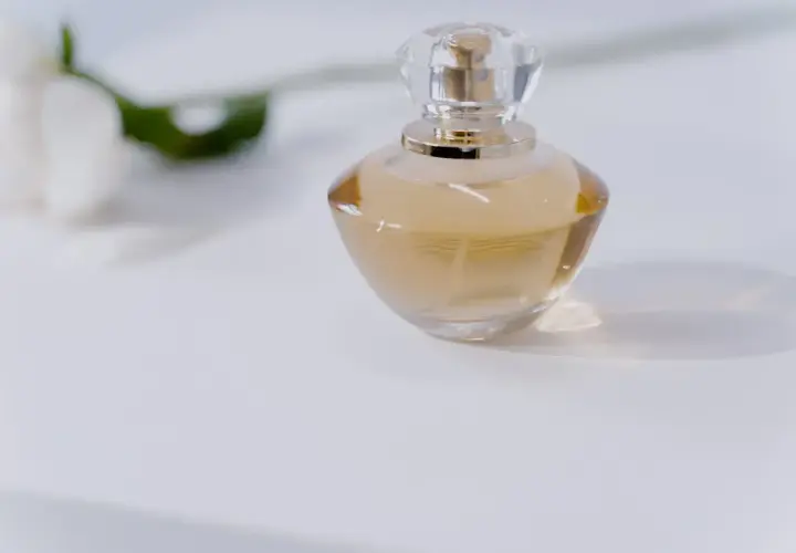 Elegancka butelka perfum na białym tle. Dowiedz się, jak sprawdzić oryginalność perfum, by cieszyć się ich unikalnym zapachem.
