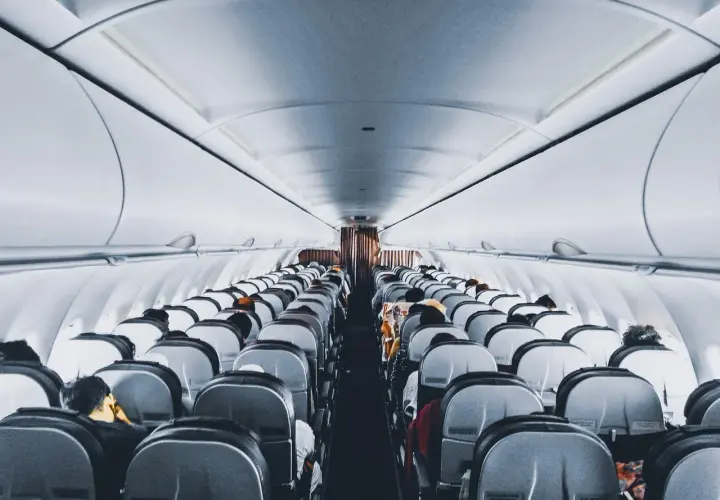 Wnętrze samolotu Wizz Air, rzędy siedzeń wypełnione pasażerami. Wizz Priority zapewnia komfortową podróż.