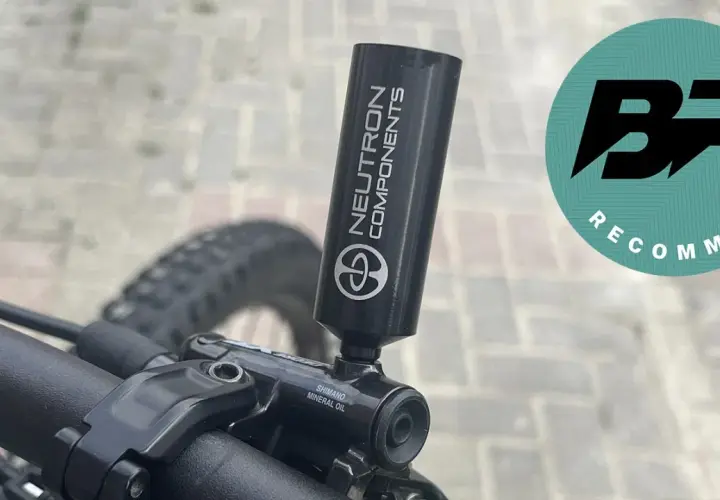 Close-up of a bicycle's mineral oil brake system with a "Neutron Components" tool attached.