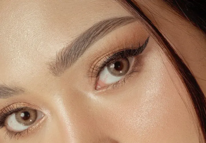 Un maquillage yeux sophistiqué avec un trait d'eye-liner fin et des fards dorés scintillants.