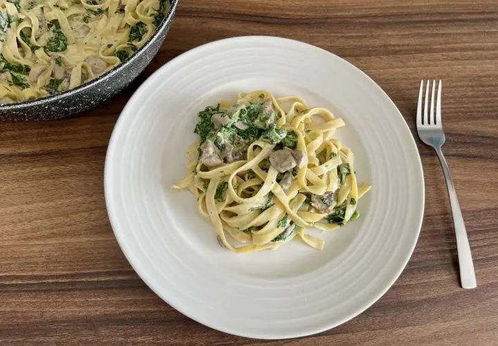 Pyszne fettuccine z kremowym sosem, pieczarkami i szpinakiem. Idealne danie na szybki obiad.