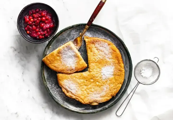 Puszysty omlet z airfryer, posypany cukrem pudrem, podany z żurawiną. Idealny na śniadanie.