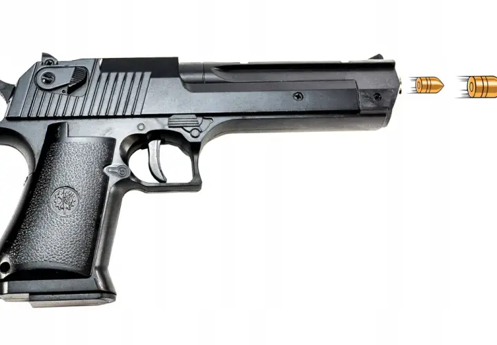 Czarny pistolet na kulki metalowe, z którego wylatują trzy pociski. To najmocniejszy pistolet na kulki metalowe, gotowy do akcji.