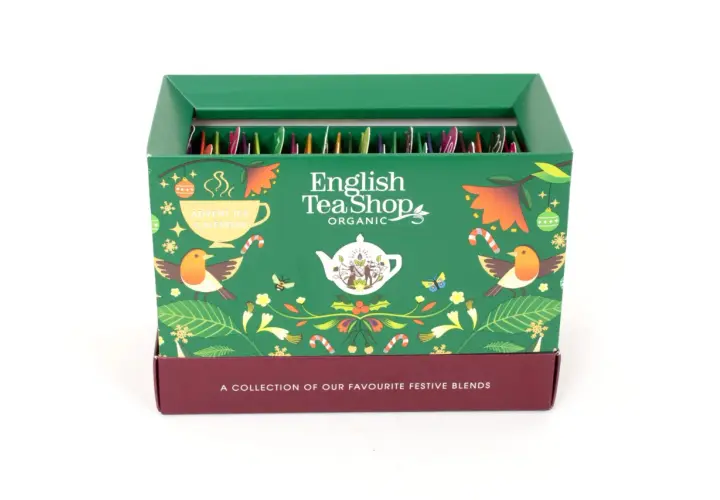 Zielony kalendarz adwentowy English Tea Shop z motywami świątecznymi, ptaszkami i liśćmi. W środku rzędy paczuszek z herbatą.