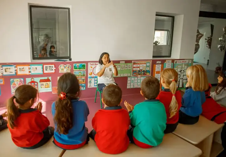 Niños atentos en una guardería o escuela infantil, escuchando atentamente a su maestra.