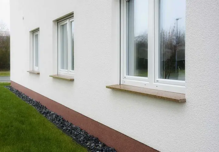 Eleganckie parapety kamienne w ciepłych kolorach dodają uroku białej elewacji.