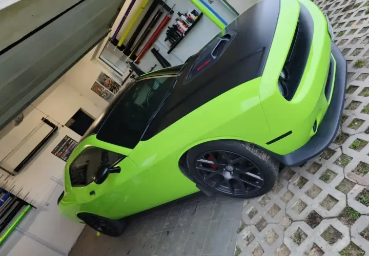 Jasnozielony Dodge Challenger z czarną maską i dachem, gotowy do oklejenia. Zastanawiasz się, ile kosztuje oklejenie auta?