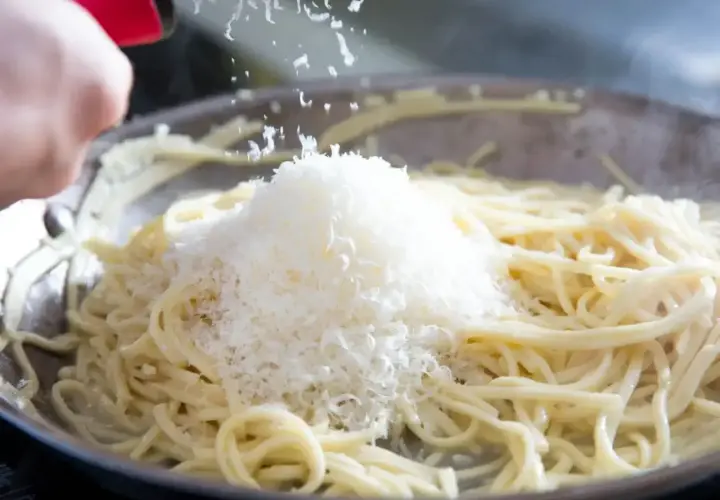 Szukając alternatywy dla parmezanu do pesto, dodaję starty ser do gorącego makaronu w patelni.