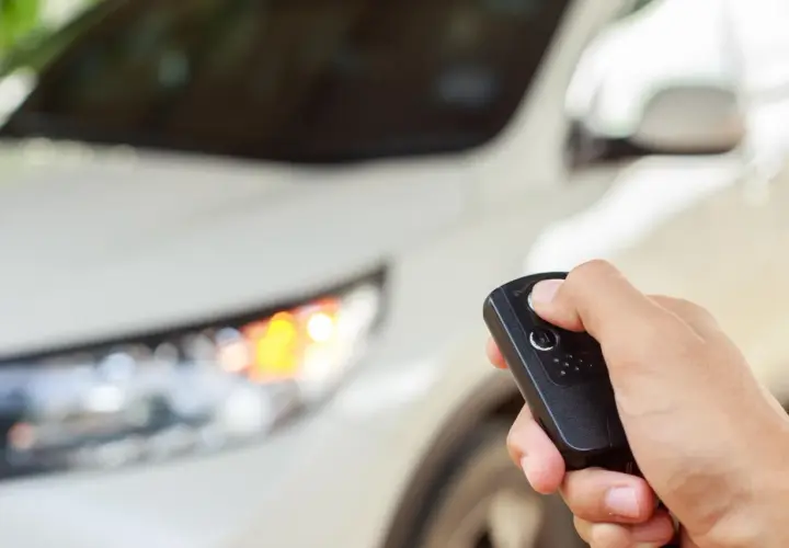 Dłoń trzyma kluczyk do samochodu, gotowa do uruchomienia silnika dzięki funkcji keyless go.