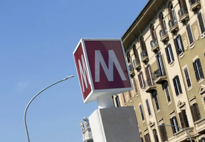 Segnale della metro con la "M" rossa su sfondo bianco, vicino a un palazzo storico. Baldo degli Ubaldi metro.