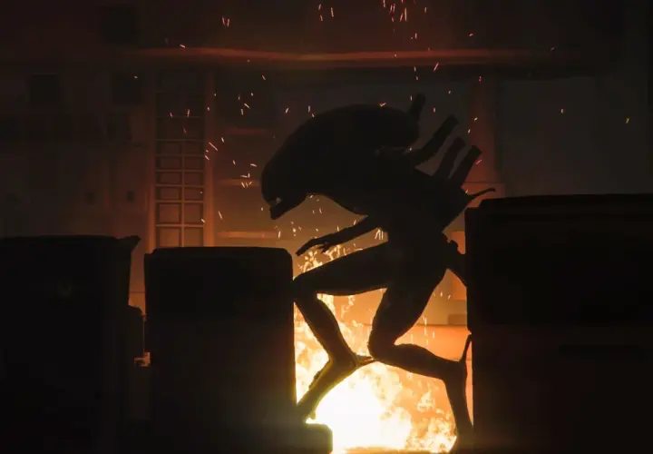 Ksenomorf w płomieniach, uciekający przez zniszczony korytarz. Scena z gry Alien Isolation 2.