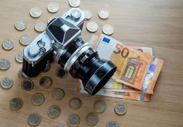 Fotografia stockowa: aparat analogowy otoczony monetami euro i banknotami 50 euro.