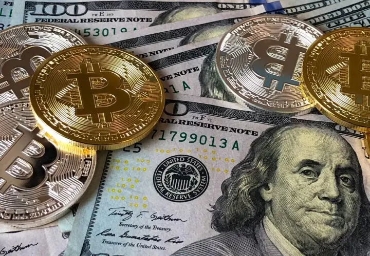 Złote i srebrne monety z symbolem Bitcoina leżą na banknotach dolarowych. Czy to przyszłość płatności w kantorze Santander Bank?