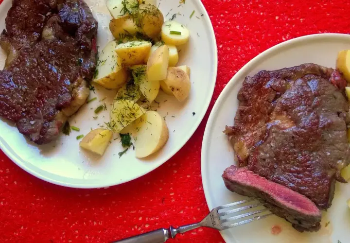 Dwa soczyste steki z ziemniakami i koperkiem. Idealny sos do steka podkreśla smak dania.